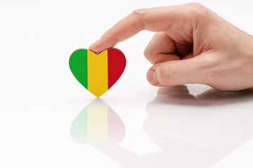Flag of Mali. Love and respect Mali. A man's hand holds a heart in the shape of the flag of Mali on...
