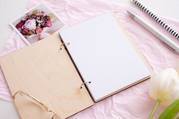Feminine mockup workspace with blank open stationery and pens with flowers. Business concept for women office blogging. Flat lay, top view.