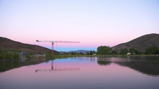 Nottingham lake park in Avon, Colorado at sunrise morning with construction crane in small mountain village ski town city in fall autumn