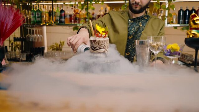 professional bartender pours near fresh alcoholic delicious cocktail liquid nitrogen beautiful and spectacular serving of drink in bar or restaurant