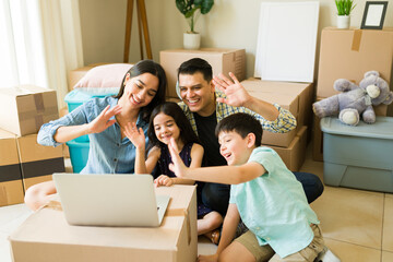 Cheerful family moving to a new home having a video call