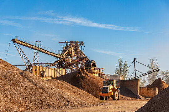 Machinery in a quarry with several conveyor belts to select the different sizes of gravel.