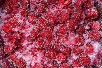 Fresh red raspberry berry, covered with granulated sugar for jam preparation in bowl, top view,...