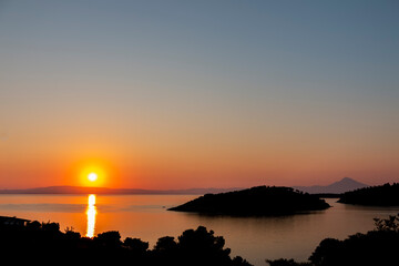 A beautiful sunrise over a serene sea, with colorful reflections shimmering on the water