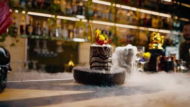close-up fresh alcoholic tasty cocktail stands on the bar near which liquid nitrogen spreads beautiful and effective serving of the drink in a bar