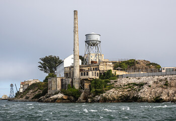 San Francisco, CA, USA - July 12, 2023: Alcatraz Island NE tip closeup with tall chimney, water...