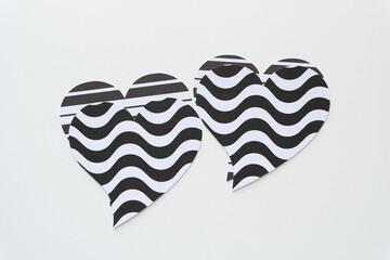 odd looking black and white hearts machine-cut from wavy pattern paper on white