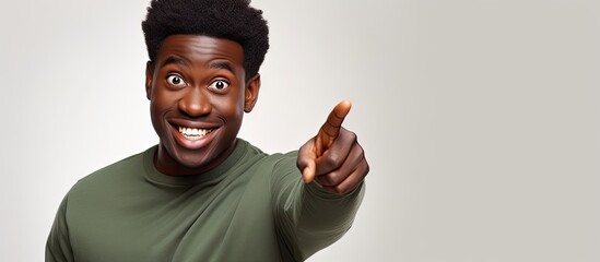 Happy African man points at blank space white background