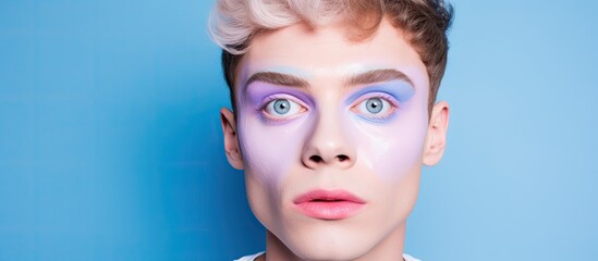 A man in makeup on blue background representing LGBT lifestyle