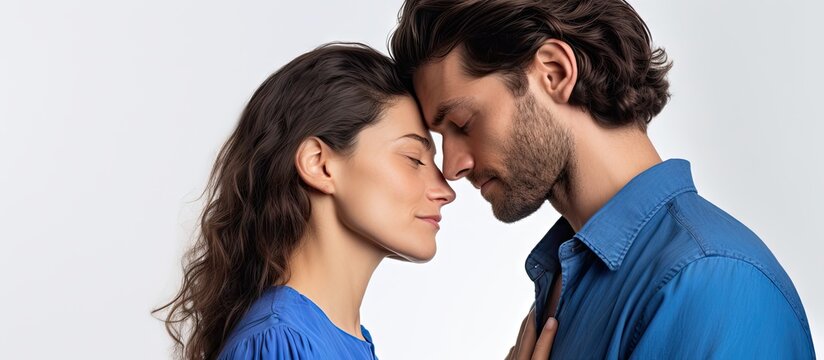 Blue shirted couple embracing and touching foreheads isolated on white