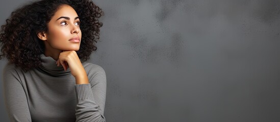 Daydreaming young woman of mixed race wearing casual clothes isolated on gray background looking away and deep in thought - obrazy, fototapety, plakaty