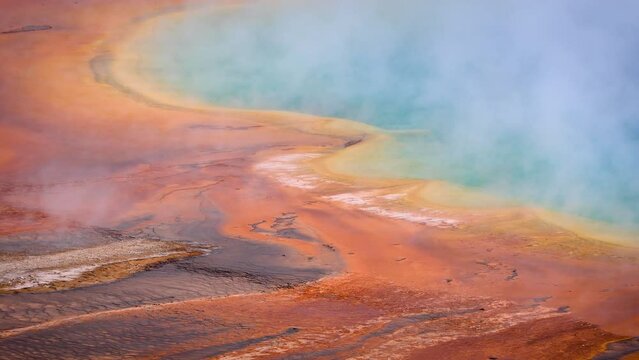 Steam rising from the Grand Prismatic Spring in Yellowstone National Park in Wyoming at dawn.