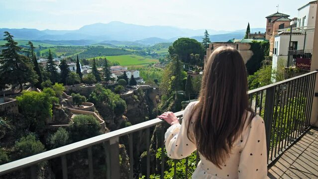 Girl walking to the edge looking in the valley of Ronda mountaintop city, Spain. Tourist woman exploring Puente Nuevo, a stone bridge spanning the old town gorge in Ronda, Andalusia in Europe
Girl wal