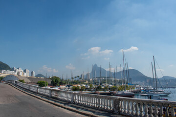 Fototapeta na wymiar Rio de Janeiro, Brazil: Urca district, view of Guanabara Bay and the harbour for fishing boats with misty city ​​skyline and Christ the Redeemer on Corcovado Mountain on the background 