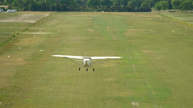 petit avion ulm qui se pose et red&eacute;colle d'une piste en herbe