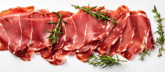 Slices of traditional dried cured pork with fresh herbs on white background top view with space for text