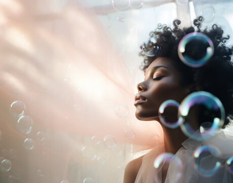Beautiful young black woman surrounded by soap bubbles.	