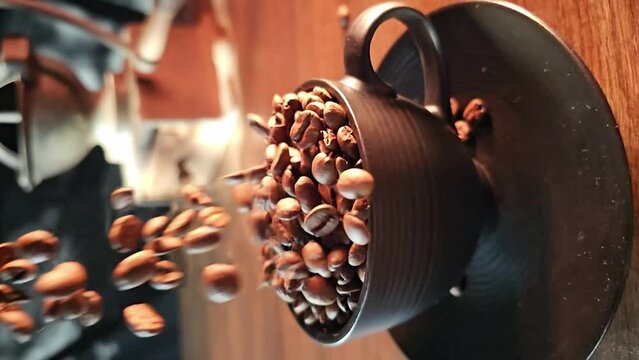 Coffee bean, coffee beans falling in super slow motian into a black cup on rustic surface, vertical video.