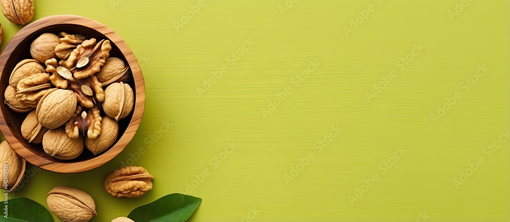 Aufkleber Walnut halves in a wooden bowl close up view colored background Nutritional concept with space for text