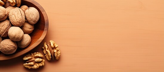 Walnut halves in a wooden bowl close up view colored background Nutritional concept with space for text