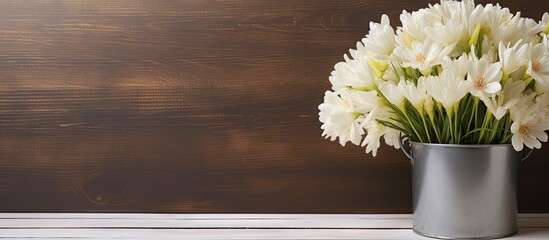 Wooden background with copy space and white flowers in metal pot