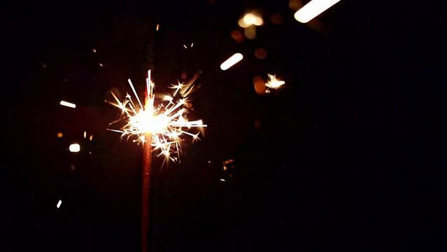 Sparkler candle, beautiful details of birthday candle burning in slow motion, black background, 4k.