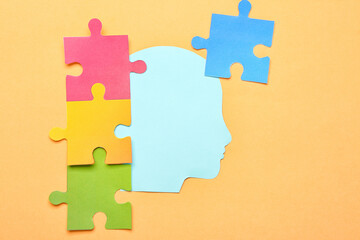 Paper human head with puzzle pieces on beige background. Logic concept