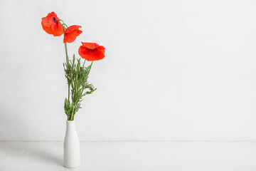 Vase with beautiful poppy flowers on light background. Remembrance Day