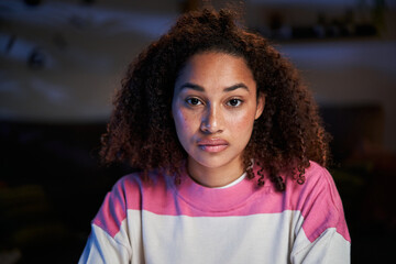 Close-up portrait of beautiful serious young latina woman. African American girl looking earnest at...