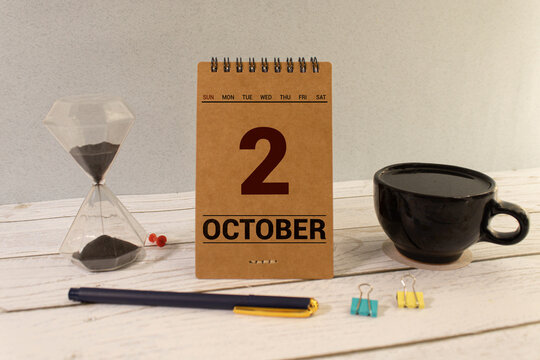 October 2 on a wooden calendar on a table or shelf.One day of the autumn month.Calendar for October.