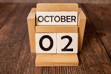 October 2 on a wooden calendar on a table or shelf.One day of the autumn month.Calendar for October.