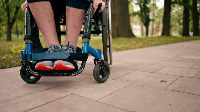 Close-up of legs of man in wheelchair in city park mobility health concept active lifestyle