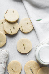 Top view of cut out rosemary sugar cookies, rosemary cookie on a white background, process of making rosemary sugar cookies