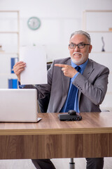 Old male employee working in the office