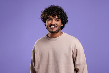 Fototapeta na wymiar Handsome young smiling man on violet background