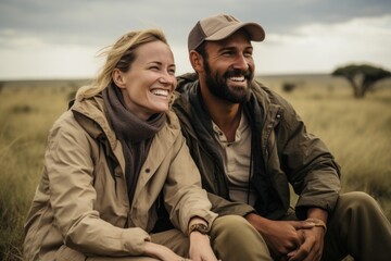 Couple in their 30s smiling at the Serengeti National Park Tanzania - obrazy, fototapety, plakaty