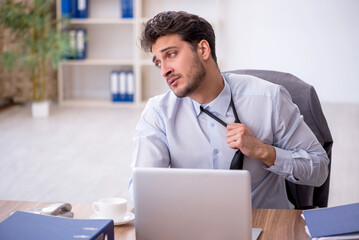 Obraz premium Young male employee working in the office