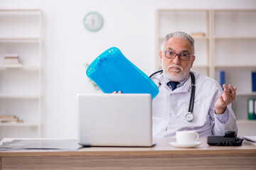 Old male doctor sitting in the clinic