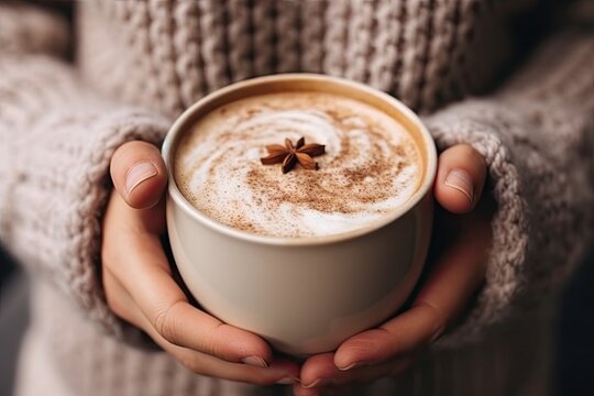 someone holding a cup of hot chocolate latte with cinnamon and star an image of someone holding a cup of hot chocolate latte