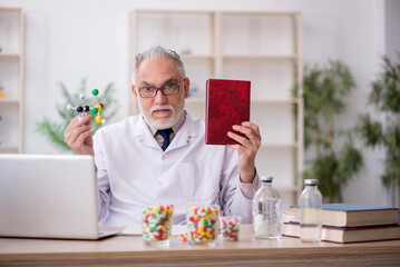Old male doctor holding molecular model