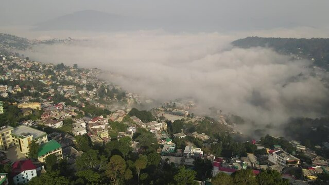 Aerial shot of almora city, situated in mountains covered with clouds. 