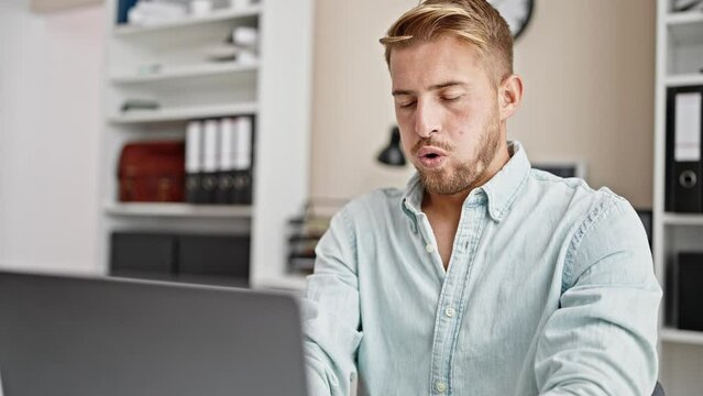 Young caucasian man business worker using laptop working stressed at office