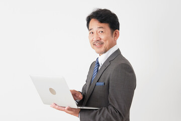 ノートパソコンを使う中年のビジネスマン　白背景