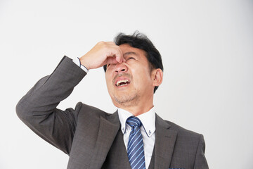眼精疲労の中年のビジネスマン　白背景