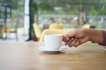 women holding a coffee cup against cafe background 