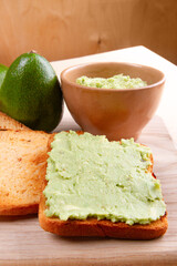 Breakfast becomes healthy with toast featuring avocado smash, set against wooden background,...