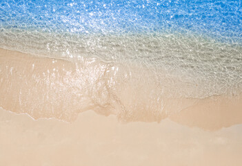 Beach sand background for summer vacation concept. Beach nature and summer seawater with sunlight light sandy beach Sparkling sea water contrast with the blue sky