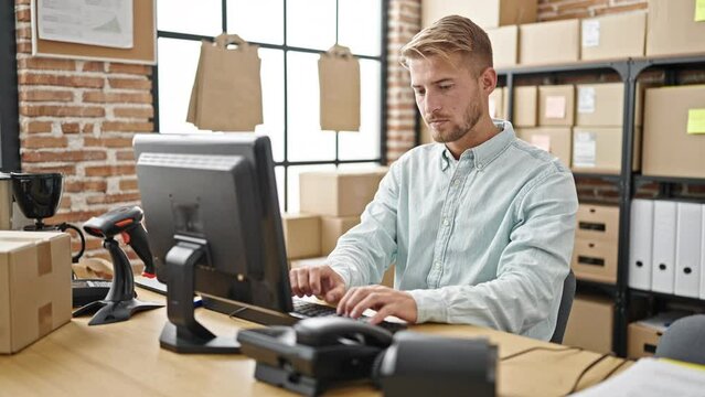 Young caucasian man ecommerce business worker talking on telephone using computer at office