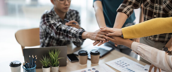 Group of business team asian partners making pile of hands at meeting