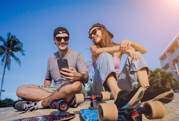 Young happy couple with skateboards taking selfie at the skatepark - Powered by Adobe
